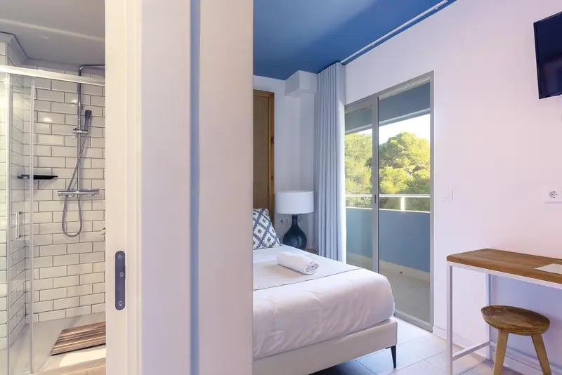 Une chambre lumineuse avec un lit simple et une salle de bain moderne.