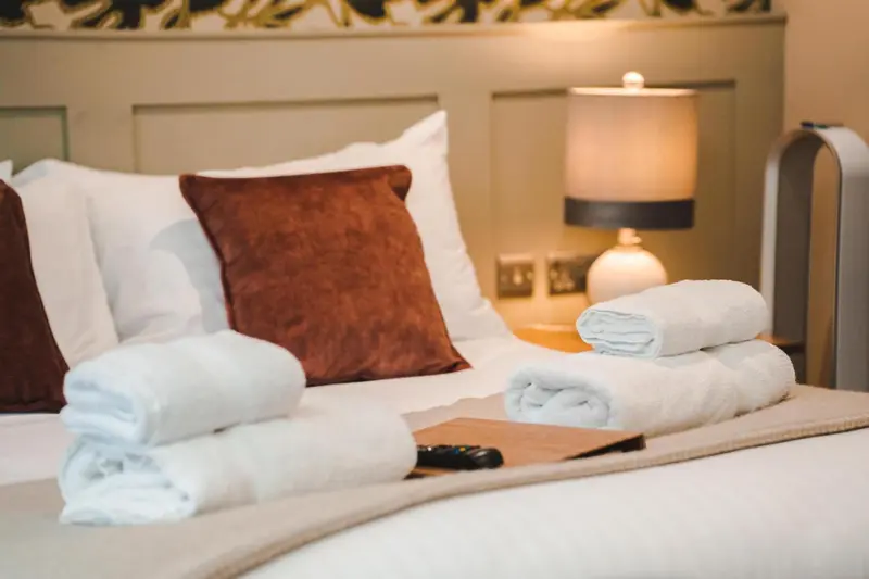 Un lit confortable avec des oreillers moelleux et des serviettes pliées.