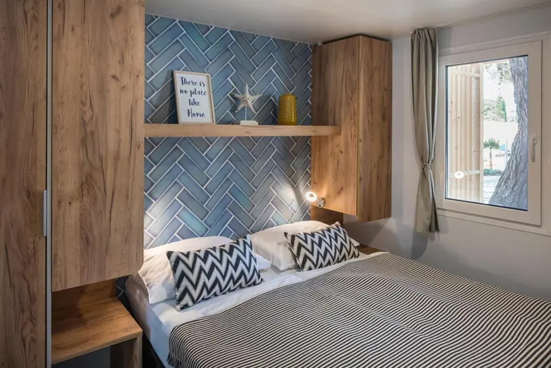 Une chambre avec un lit double et un mur décoratif bleu.
