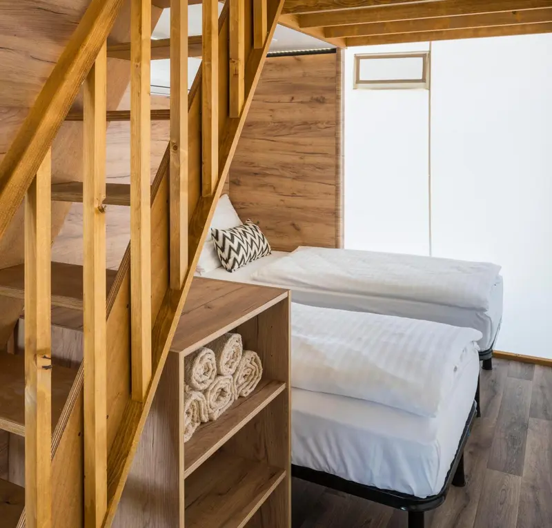 Une chambre avec un lit superposé et des rangements intégrés.