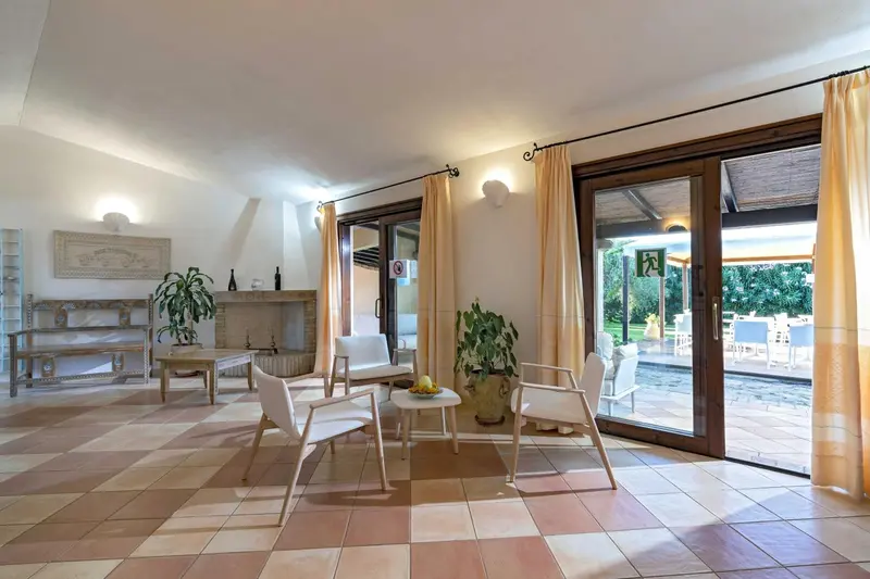 Espace de séjour lumineux avec canapés et accès à une terrasse.