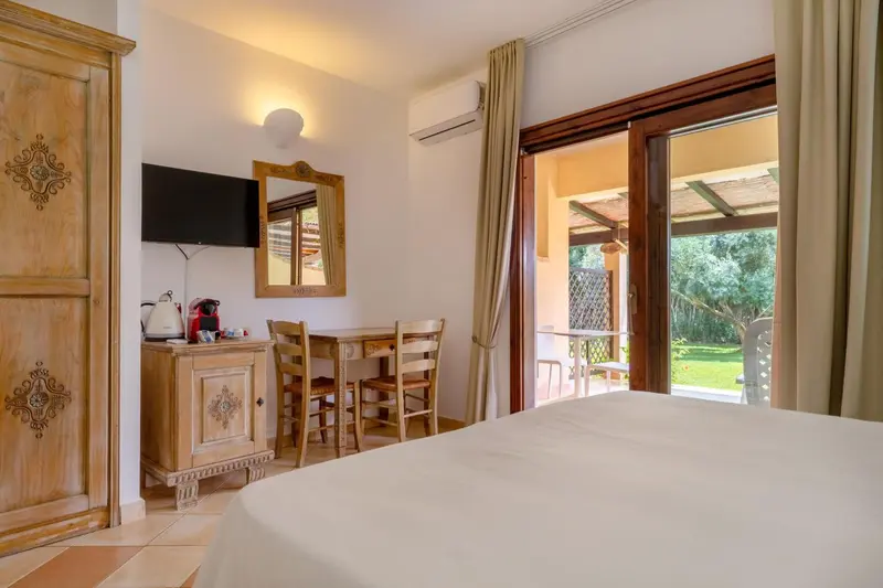 Une chambre lumineuse avec un coin repas donnant sur une terrasse.