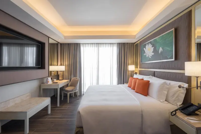 Une chambre lumineuse avec un grand lit et un bureau.