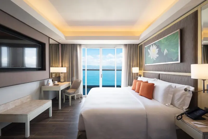 Une chambre lumineuse avec un grand lit et une vue sur la mer.