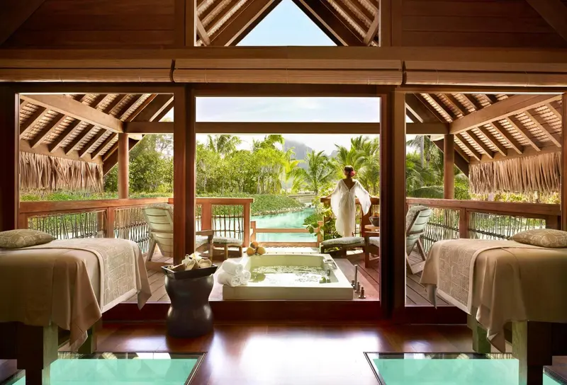 Espace de relaxation avec lits de massage et vue sur un jardin tropical.