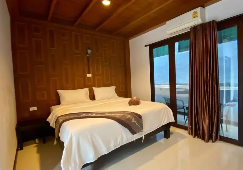 Une chambre lumineuse avec un grand lit et un accès à une terrasse.