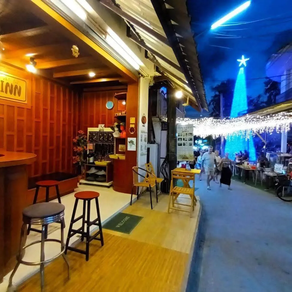 Une terrasse ombragée avec des tabourets de bar et un comptoir.