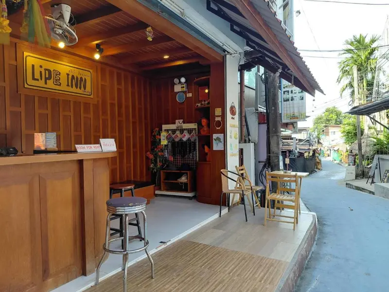 Façade d'un petit établissement avec un comptoir d'accueil et quelques tables.