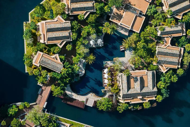 Vue aérienne d'un complexe hôtelier avec piscine et végétation luxuriante.