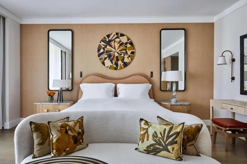Une chambre lumineuse avec un grand lit et des miroirs décoratifs.
