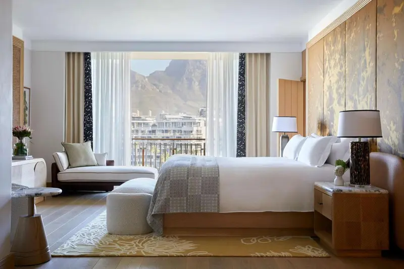 Une chambre lumineuse avec un grand lit et une vue sur un paysage montagneux.