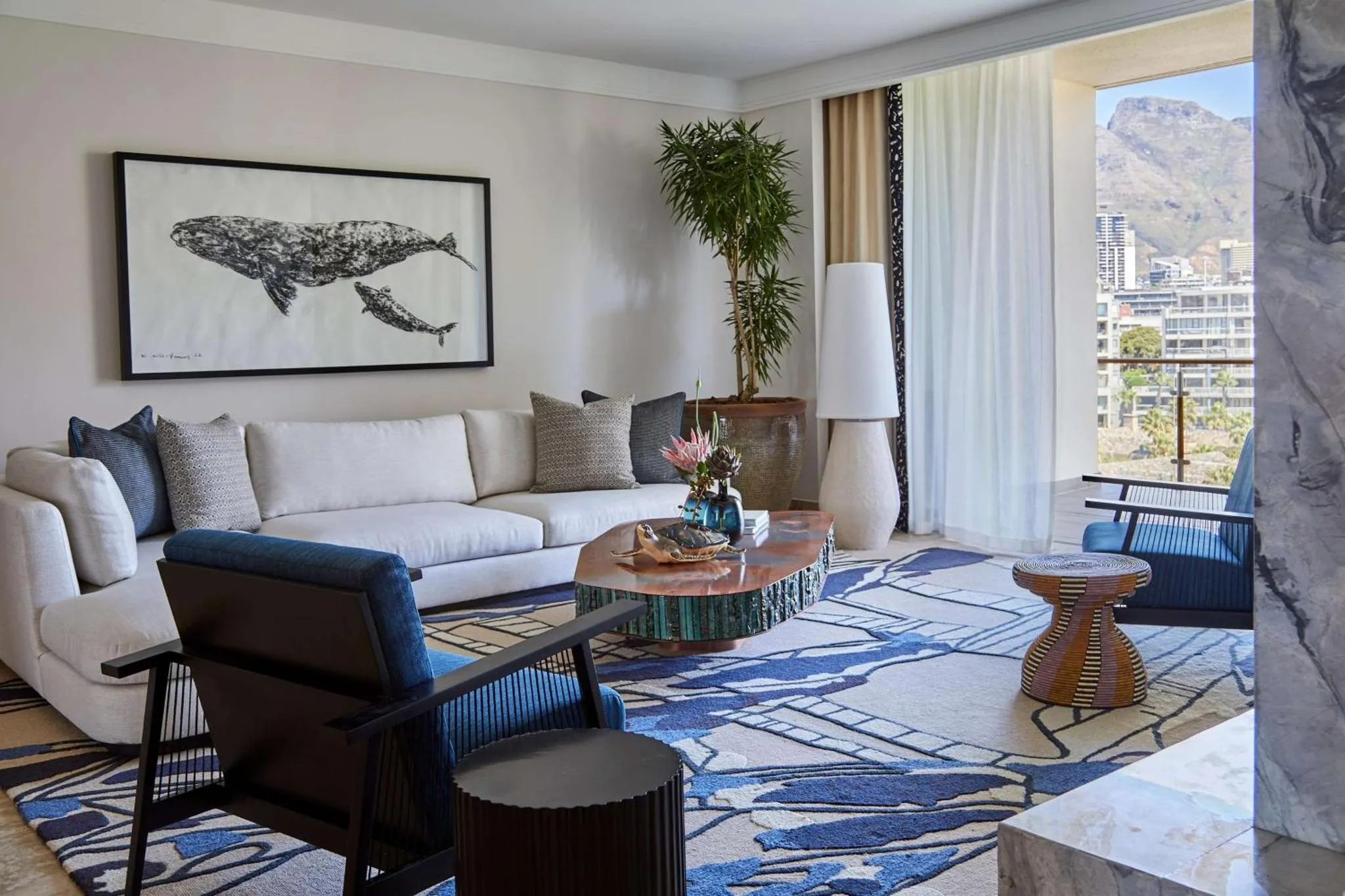 Un salon moderne avec canapés, fauteuils et une vue sur la mer.