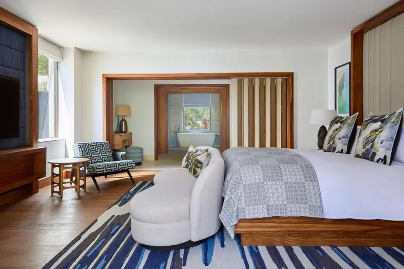 Une chambre lumineuse avec un grand lit et un espace détente.