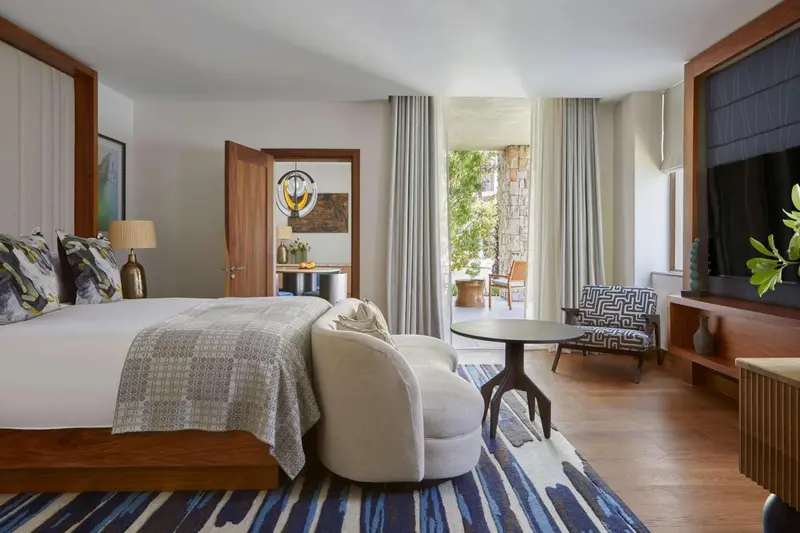 Une chambre lumineuse avec un grand lit et un coin salon.