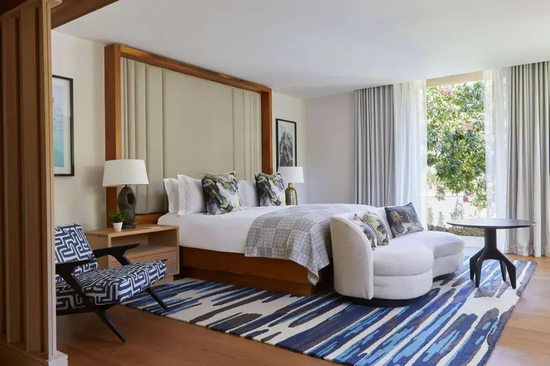 Une chambre lumineuse avec un grand lit et un espace détente.