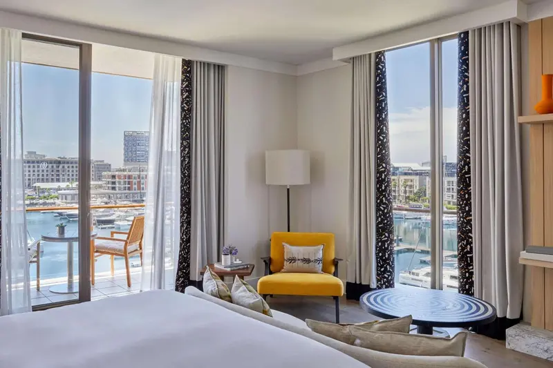 Une chambre lumineuse avec un coin salon et une vue sur le port.