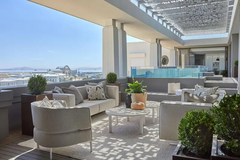 Espace de détente extérieur avec mobilier confortable et vue sur la ville.