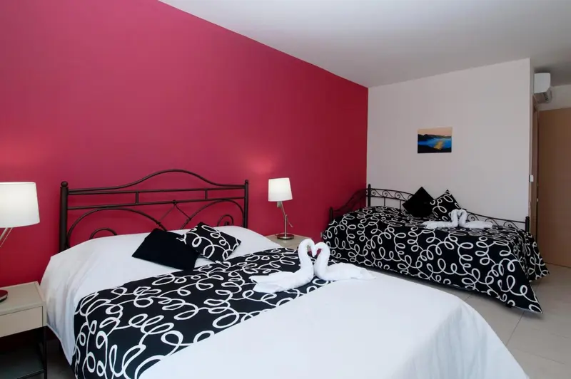Une chambre avec deux lits décorés de motifs noirs et blancs.