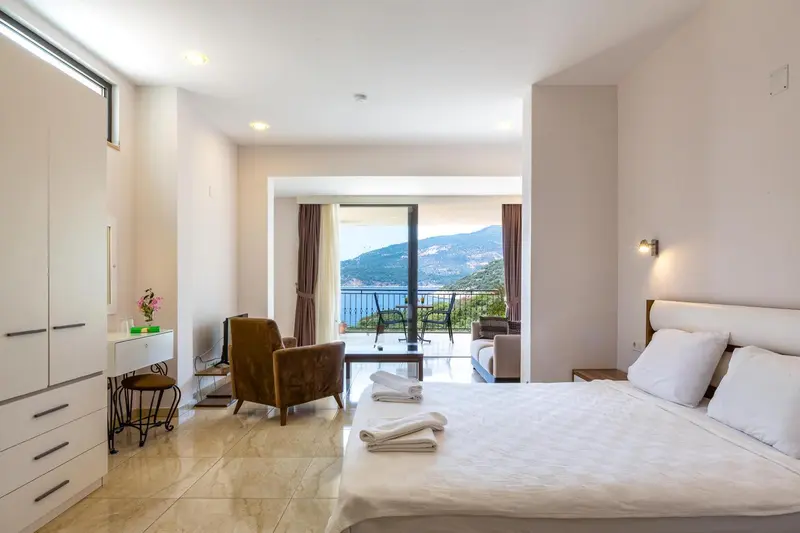 Une chambre lumineuse avec un grand lit et une vue sur la mer.