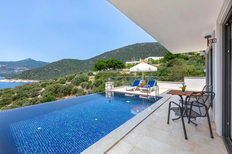 Terrasse avec piscine à débordement et vue sur la côte.