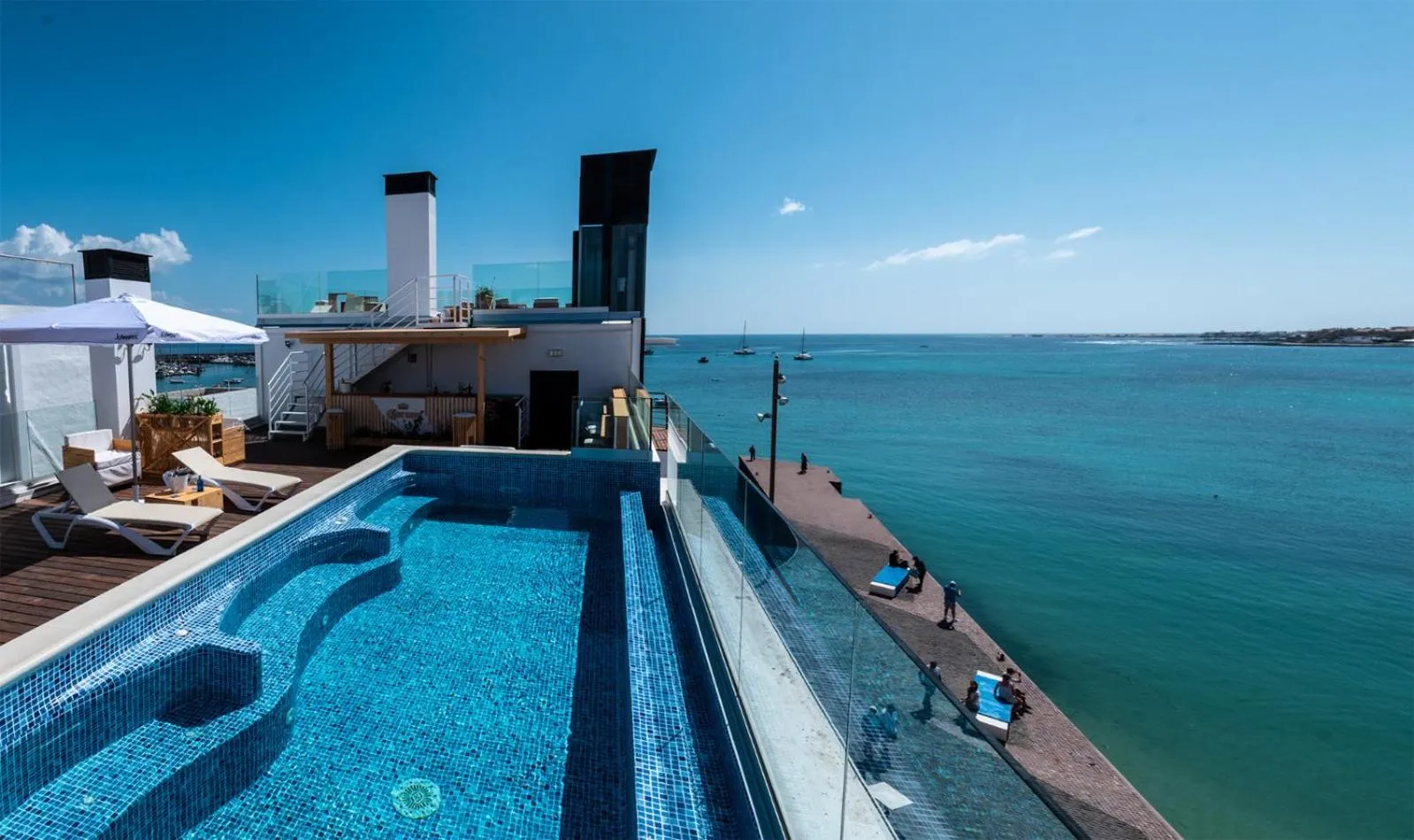 Terrasse avec piscine et vue sur la mer.
