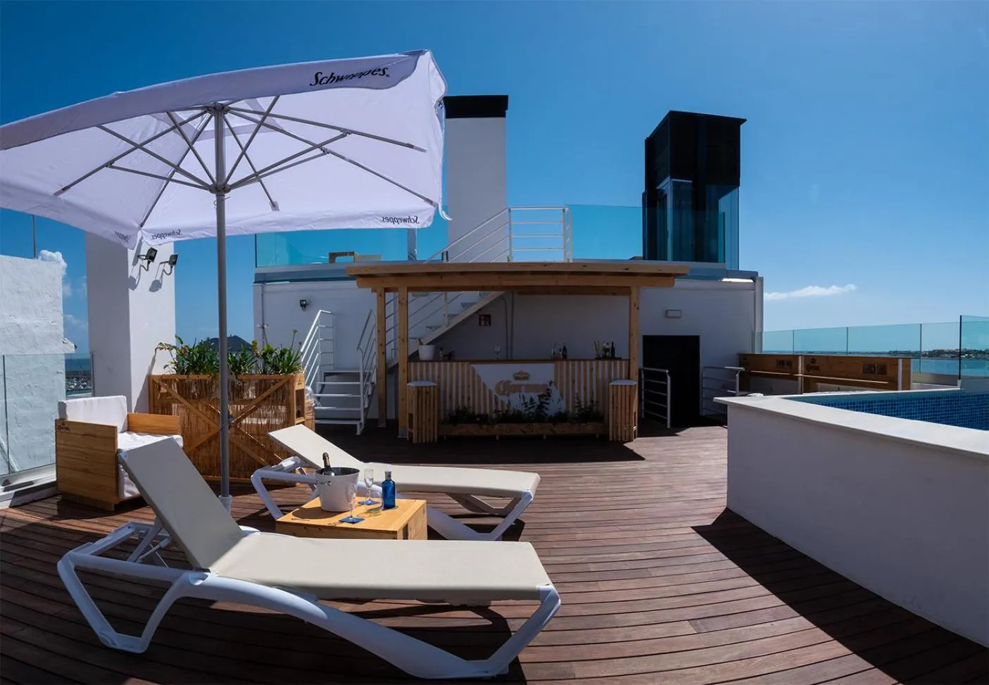 Terrasse aménagée avec transats et parasols, vue sur la mer.