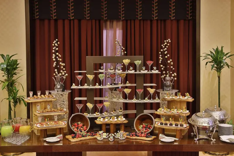 Un buffet de desserts variés est présenté sur une table richement décorée.