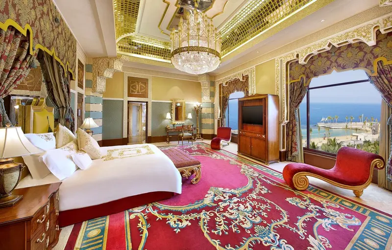 Chambre richement décorée avec un grand lit et une vue sur la mer.