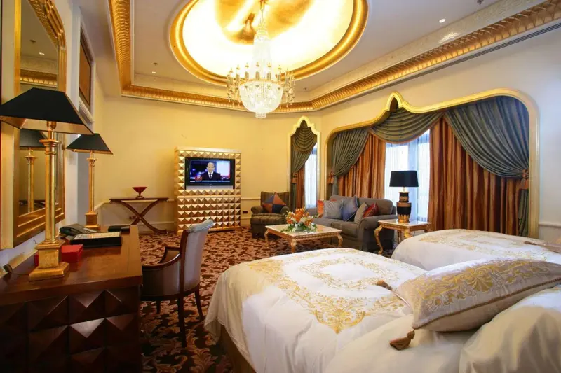 Une chambre richement décorée avec un lit et un coin salon.