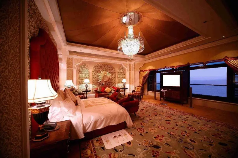 Une chambre richement décorée avec un grand lit et un lustre.