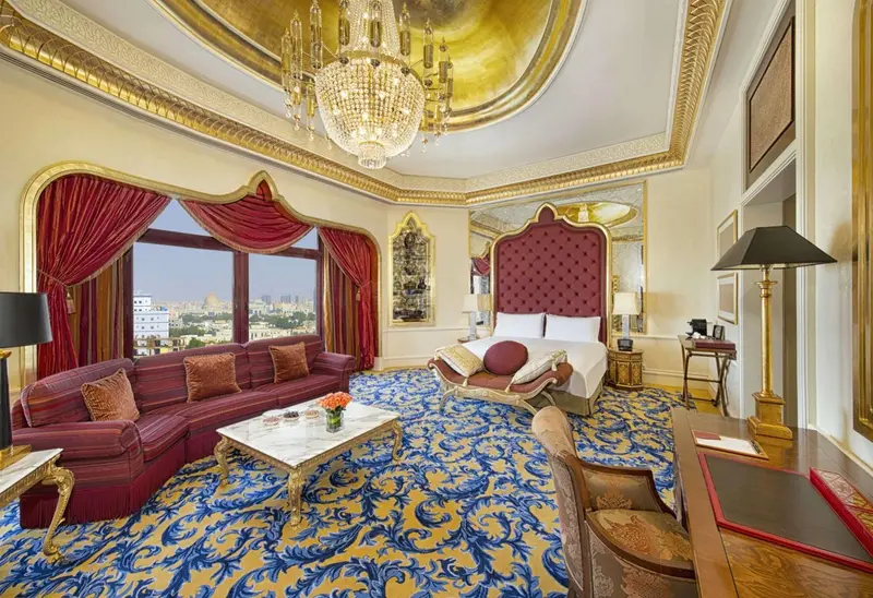 Une chambre richement décorée avec un grand lit et un canapé rouge.