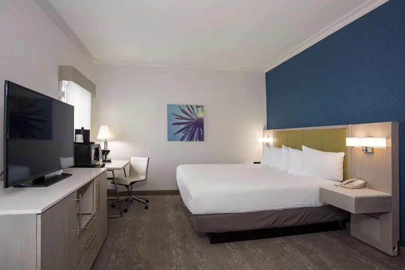 Une chambre d'hôtel lumineuse avec un grand lit et un téléviseur.