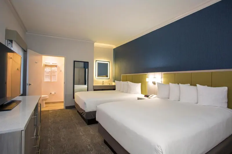 Une chambre d'hôtel avec deux lits doubles et un espace bureau.