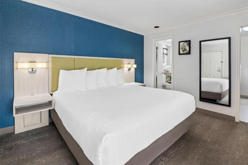 Une chambre d'hotel avec un grand lit blanc et un mur bleu.
