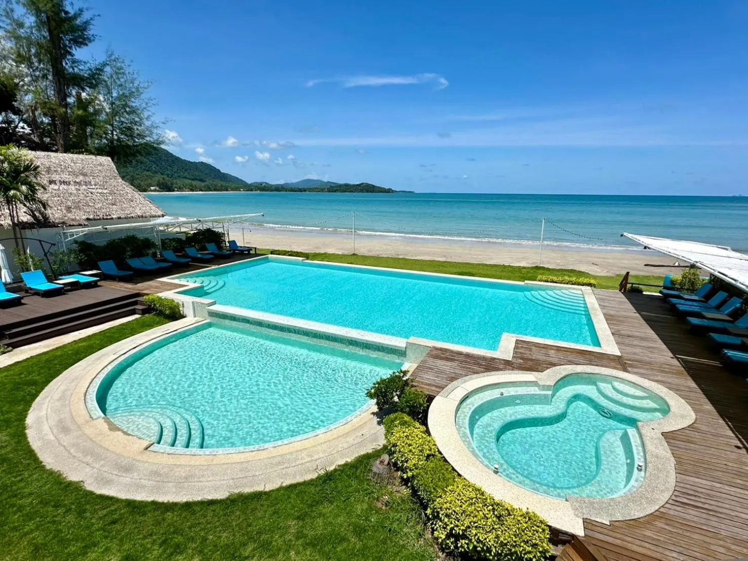 Piscine bleue avec espace détente et vue sur la mer.