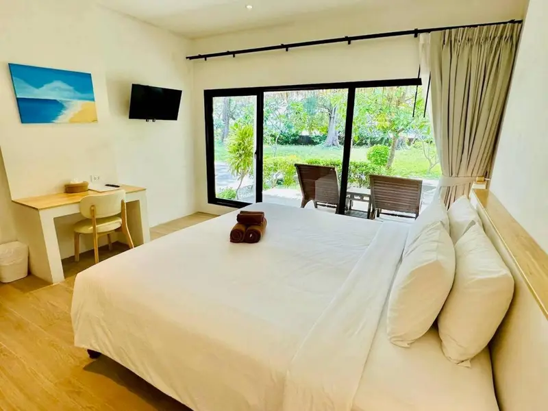 Une chambre lumineuse avec un grand lit et un accès à une terrasse.