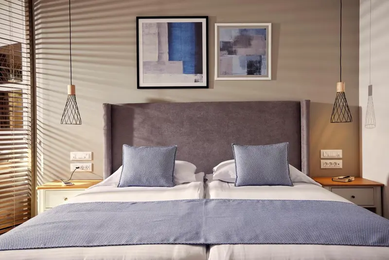 Une chambre avec un grand lit et des tableaux au mur.