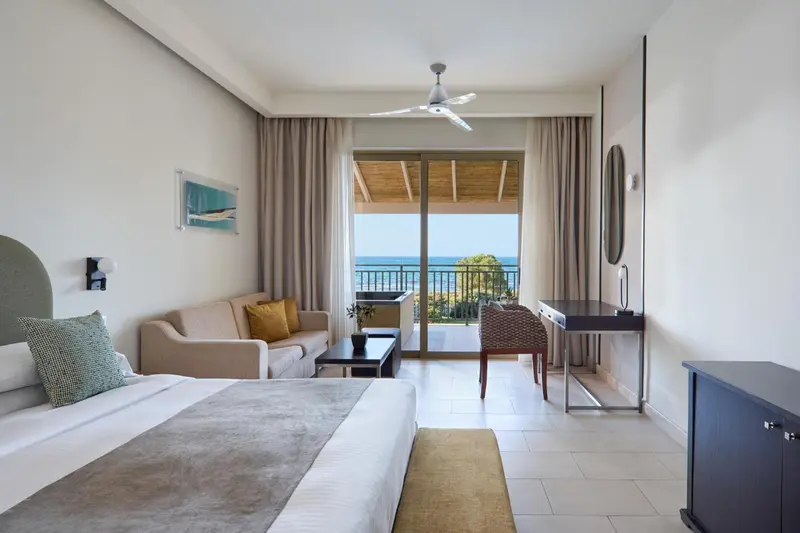 Une chambre lumineuse avec canapé et vue sur la mer.