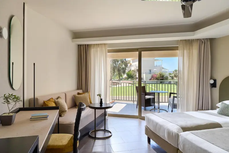 Une chambre lumineuse avec un canapé et un accès à une terrasse.