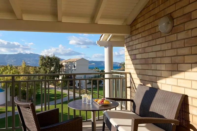 Terrasse avec mobilier et vue sur la mer et les montagnes.