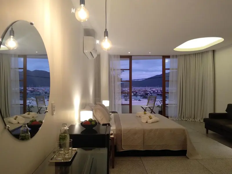 Une chambre lumineuse avec un grand lit donnant sur une vue sur la mer.