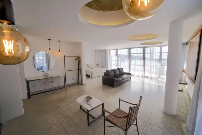 Espace de vie lumineux avec canapé, table basse et bureau.