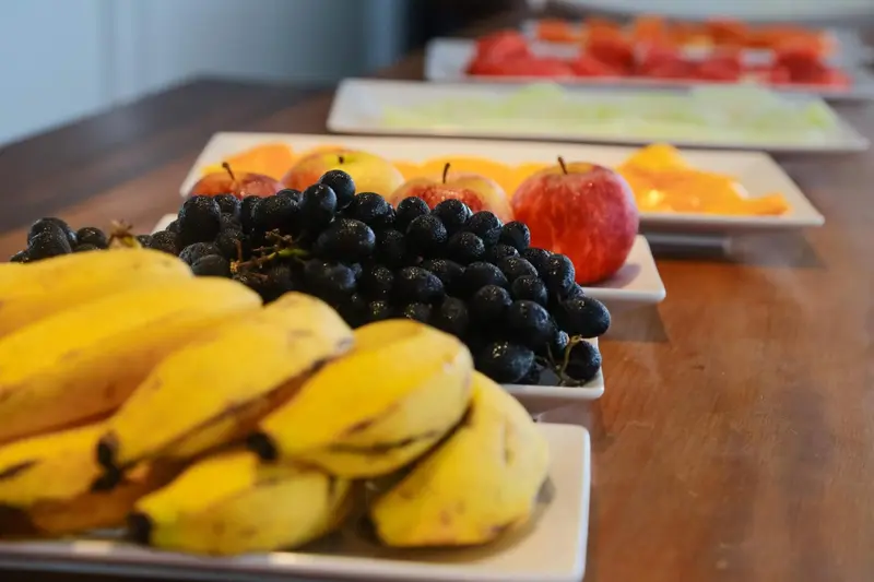 Assortiment de fruits frais disposés sur des plateaux blancs.