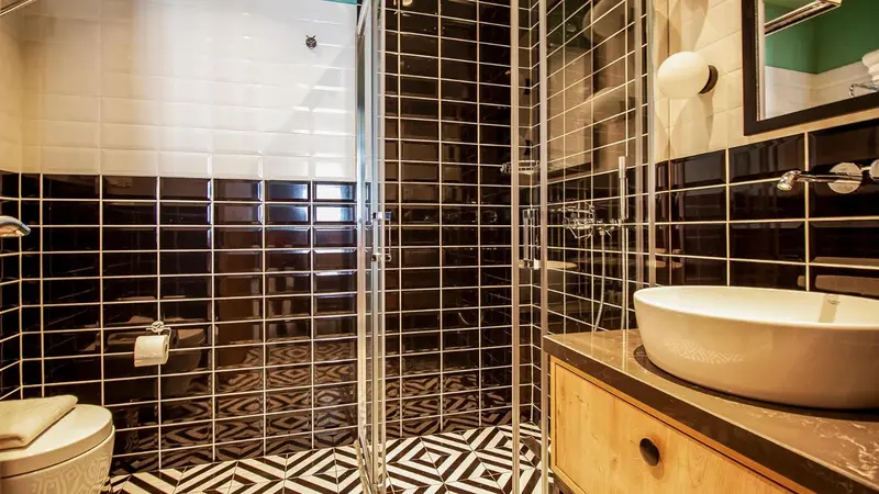 Une salle de bain moderne avec une douche à l'italienne et un carrelage noir et blanc.