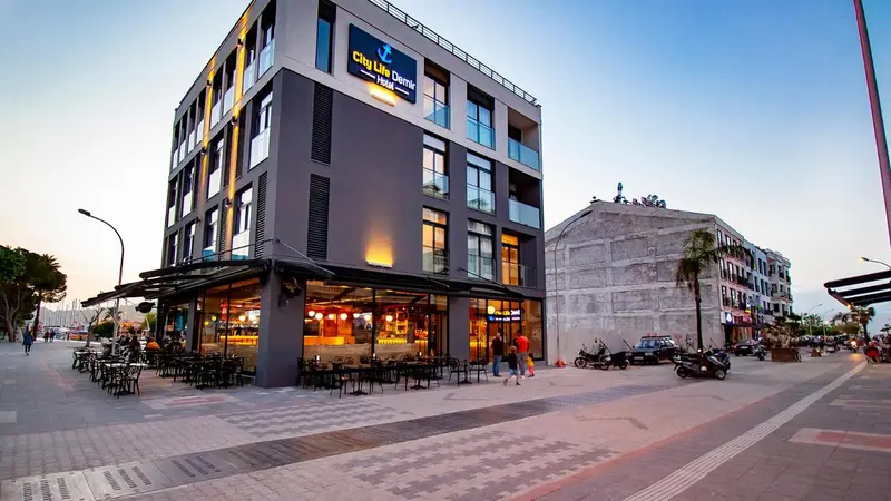 Façade d'un bâtiment moderne avec un restaurant en rez-de-chaussée et une rue animée.