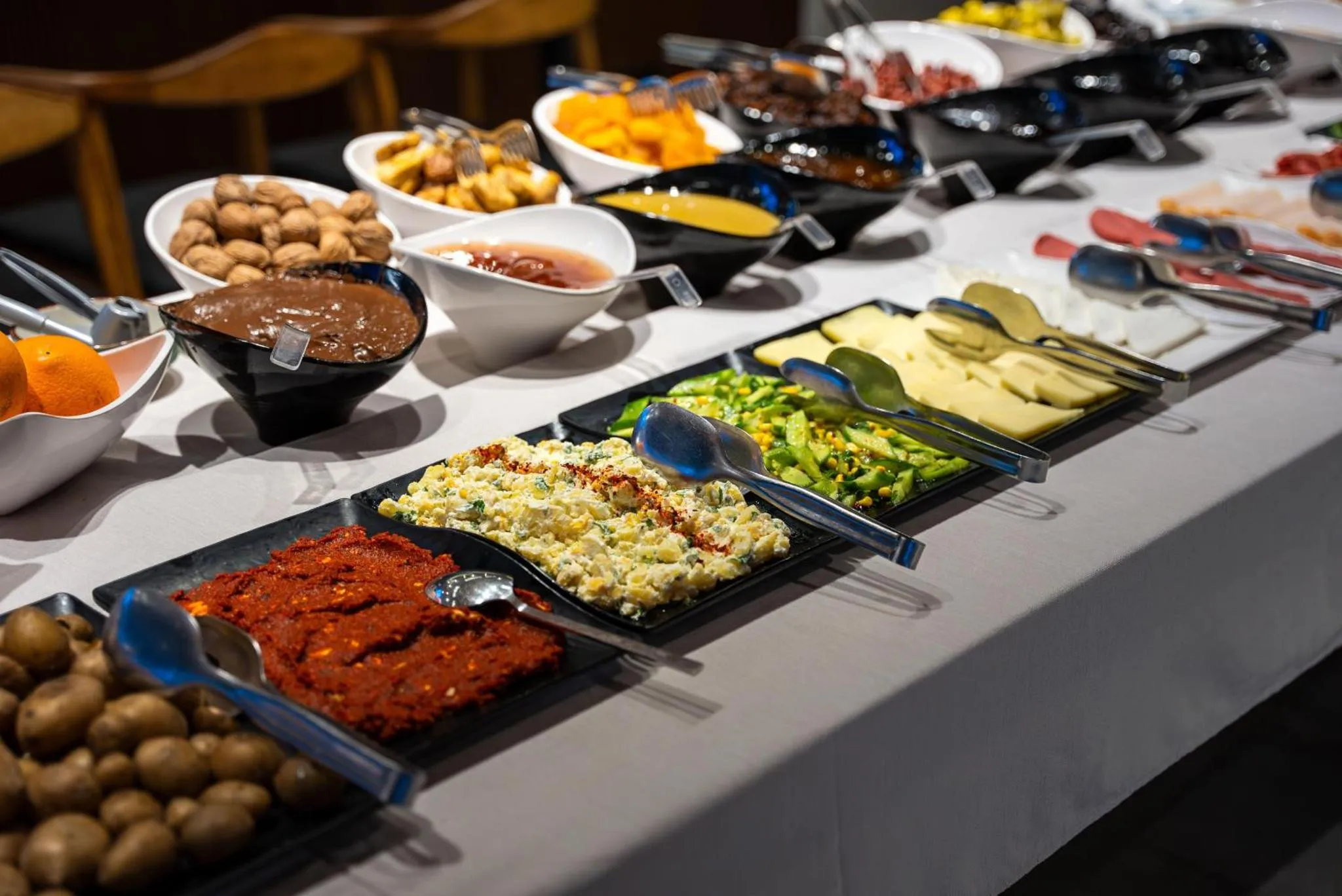 Un buffet propose une variété de plats et de salades.