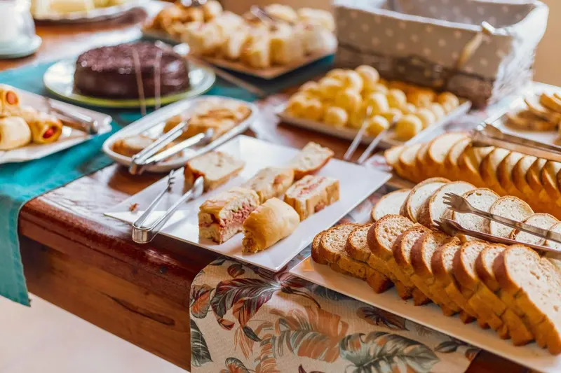 Une table garnie de viennoiseries, de pâtisseries et de pains.