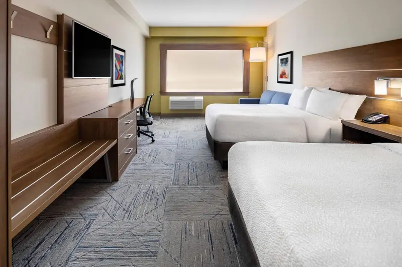 Chambre d'hôtel avec deux lits et un espace de travail.