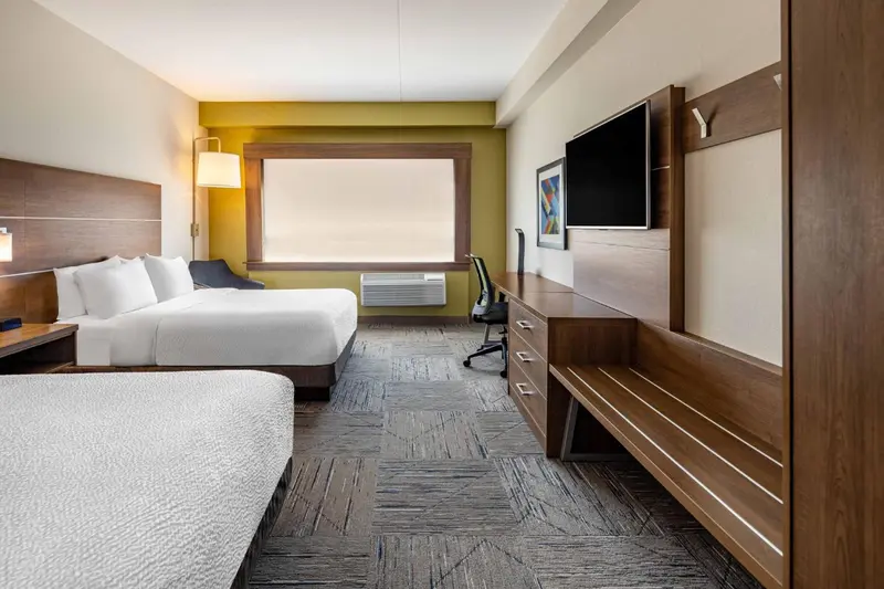 Une chambre d'hôtel lumineuse avec un grand lit et un bureau.