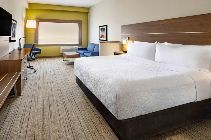 Une chambre d'hotel avec un grand lit et un espace bureau.
